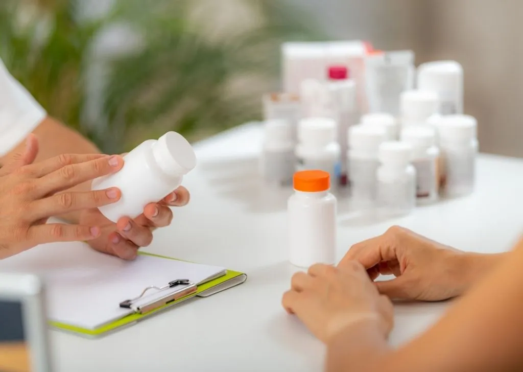 A health specialist inspecting a bottle of pills brought in by a pharmaceutical importer in Malaysia.