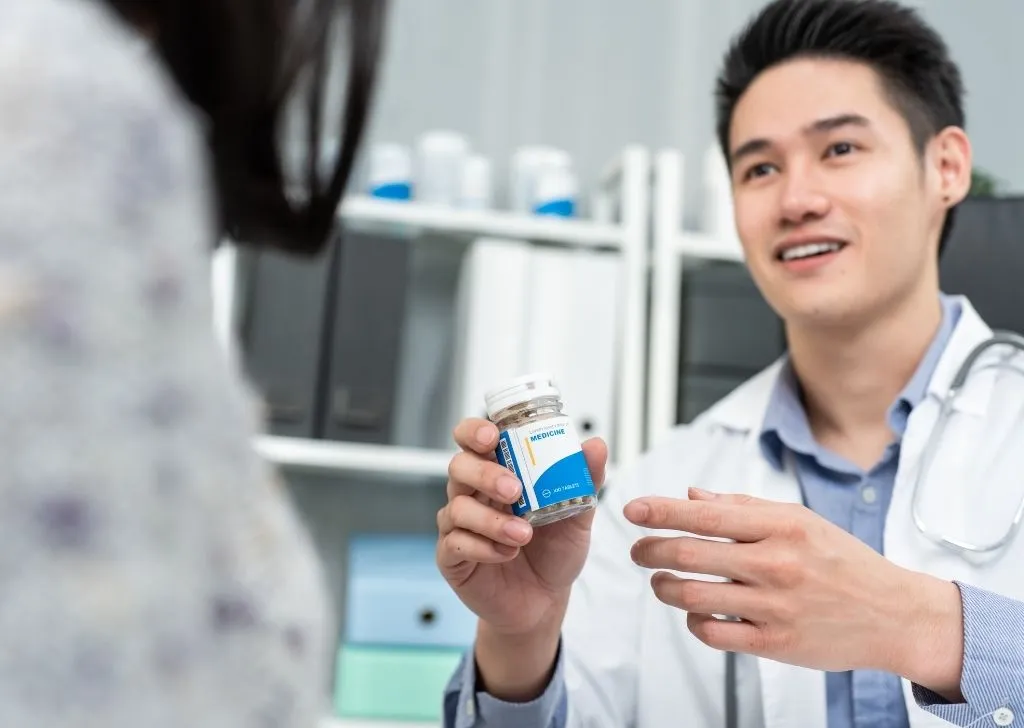 A licensed pharmacist explaining the effects of the medication to a patient.