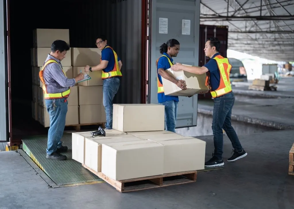 A group of warehouse workers transporting goods into a truck from a pharmaceutical importer in Malaysia.