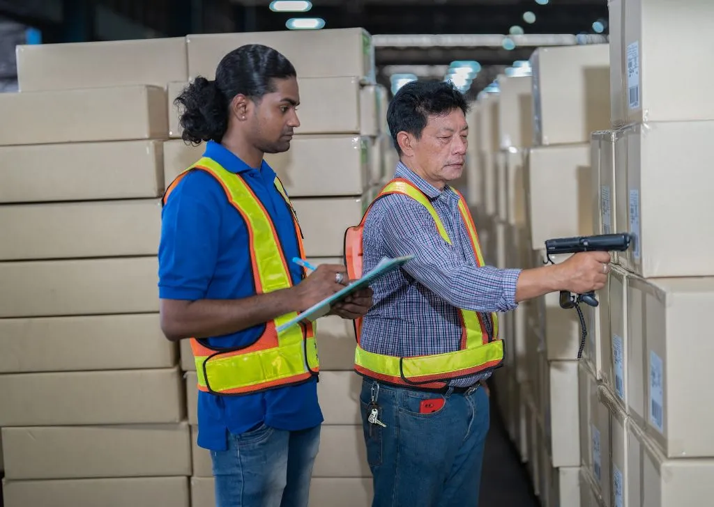 A warehouse manager inspecting a shipment brought in by a pharmaceutical importer in Malaysia to make sure they are properly labeled.