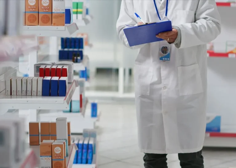 A pharmacist inspecting a shelf of medical products brought in by a pharmaceutical importer in Malaysia.