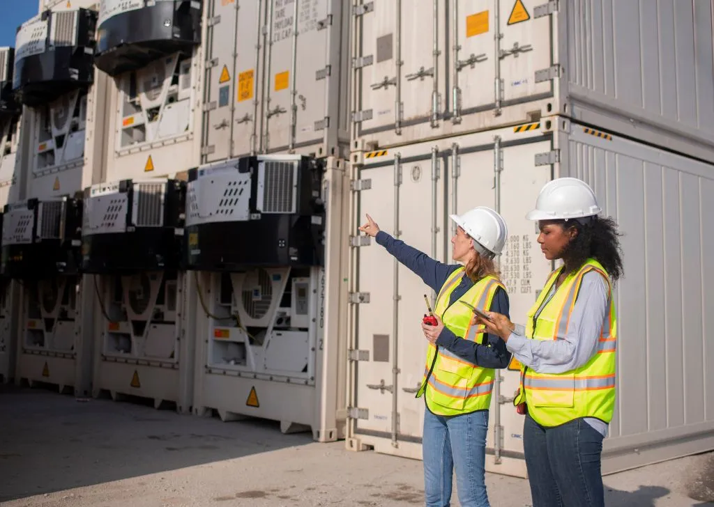 Warehouse workers inspecting cargo shipment for cold chain logistics in Malaysia.