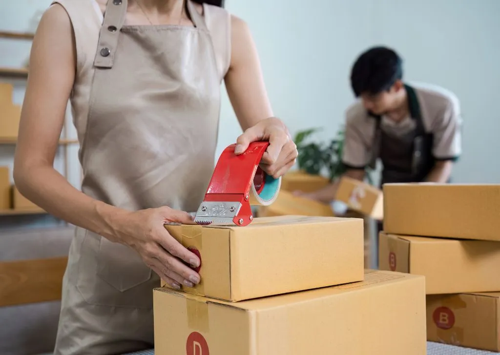 Warehouse staff working in cold chain logistics making sure packages are sealed properly.
